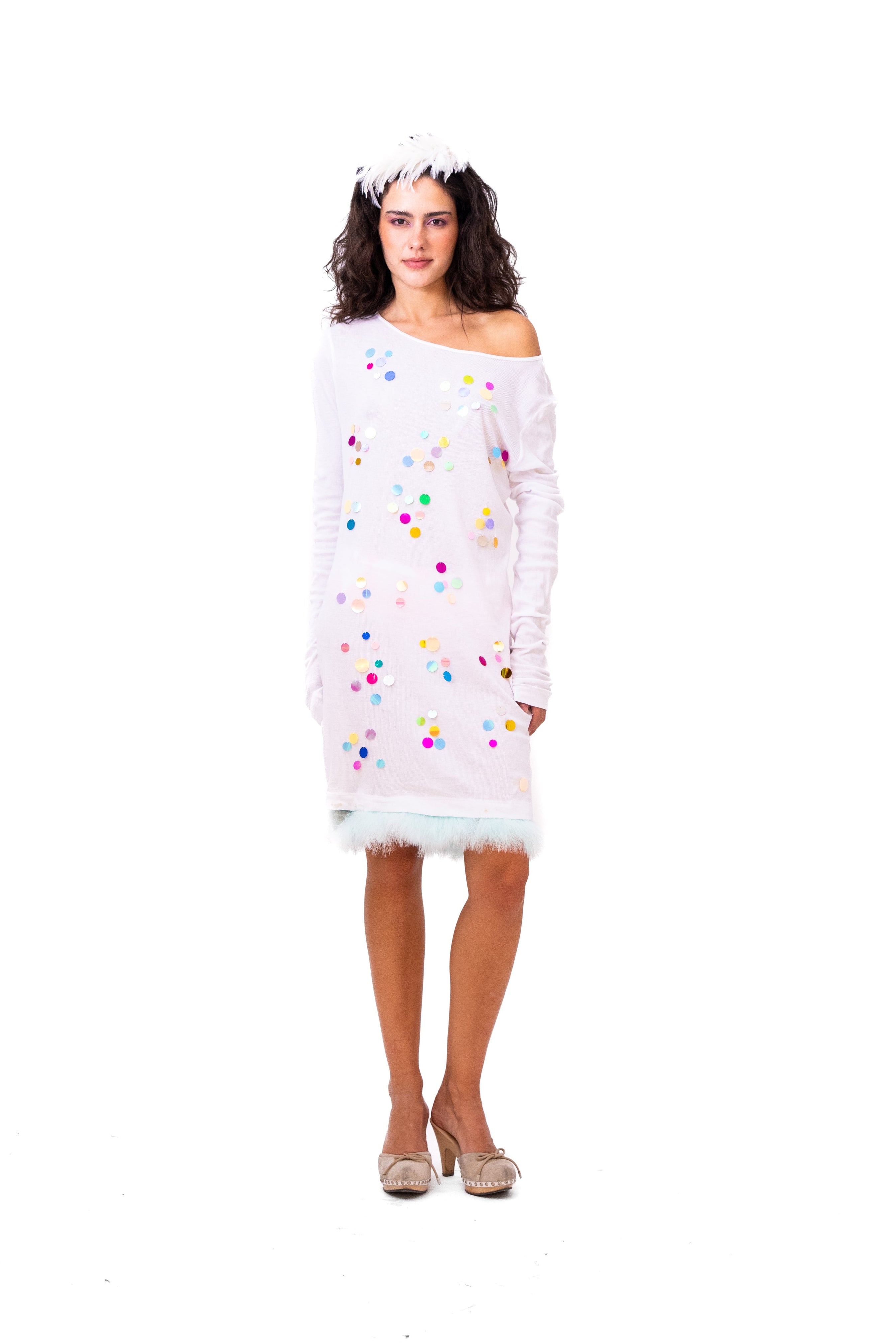 Woman wearing a white off-shoulder dress with colorful polka dots on a white background