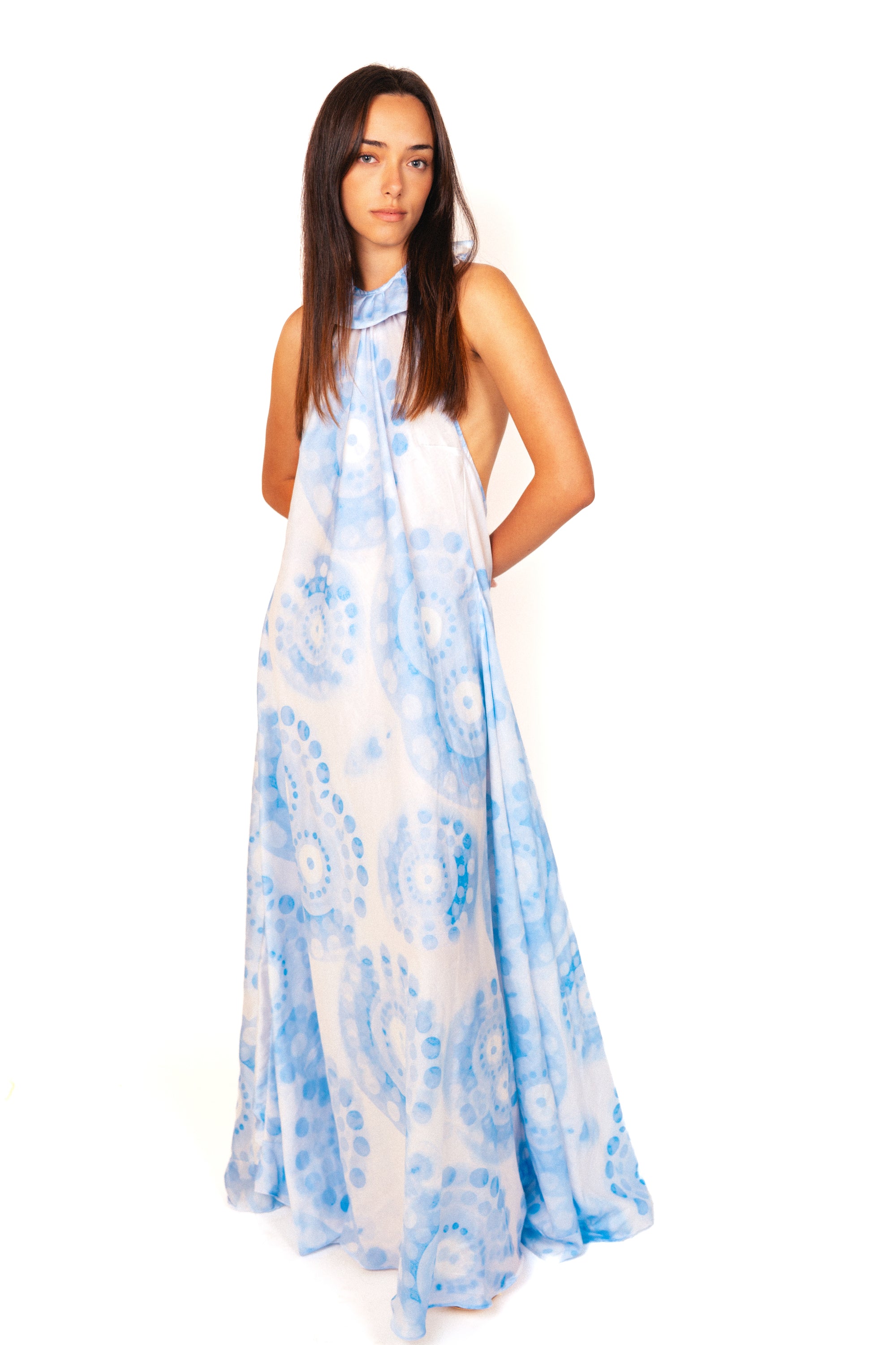 Woman wearing a blue and white patterned dress on a white background